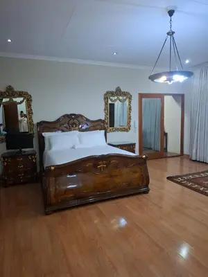 a bedroom with a wooden bed and two mirrors at Aaybee for Four in Midrand