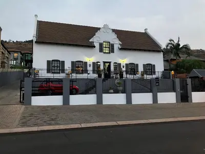 a white building with a fence in front of it at Montana Cape House in Pretoria