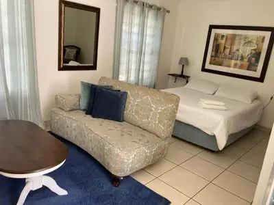 a living room with a couch and a bed at Montana Cape House in Pretoria