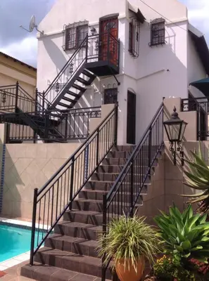 a building with stairs next to a swimming pool at Montana Cape House in Pretoria