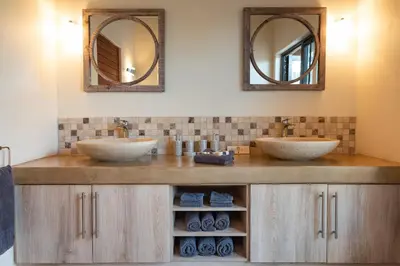 two sinks in a bathroom with two mirrors at Villa Marula in Hoedspruit