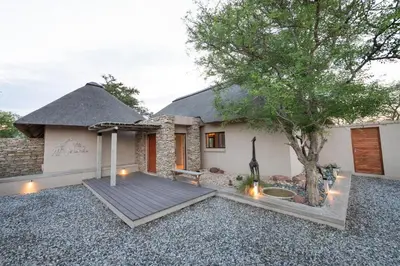 a house with a wooden deck and a tree at Villa Marula in Hoedspruit