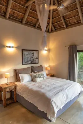 a bedroom with a large bed and a wooden ceiling at Villa Marula in Hoedspruit
