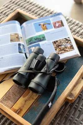 a pair of binoculars and a book on a table at Villa Marula in Hoedspruit
