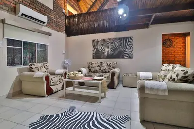 a living room with couches and a table at Qëtesia- Oasis of tranquility in Marloth Park
