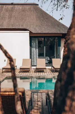 a villa with a swimming pool and chairs at Villa Scarabee in Hoedspruit