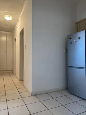 an empty hallway with a refrigerator in a room at Top Building in Pretoria