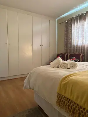 a bedroom with a large bed with white cabinets at Top Building in Pretoria