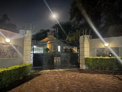 a gate to a house at night with lights at Top Building in Pretoria