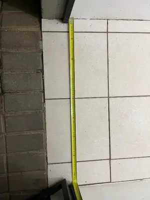 a yellow ruler on the side of a brick wall at Top Building in Pretoria