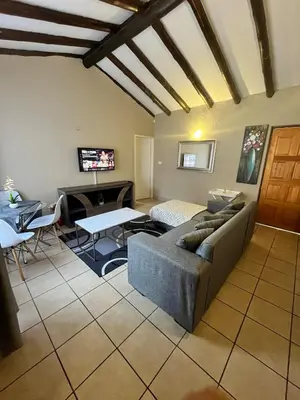 a living room with a couch and a table at Exquisite cottage in Doringkloof in Centurion
