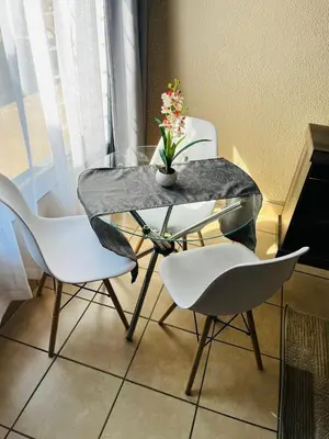 a table with chairs and a vase with flowers on it at Exquisite cottage in Doringkloof in Centurion