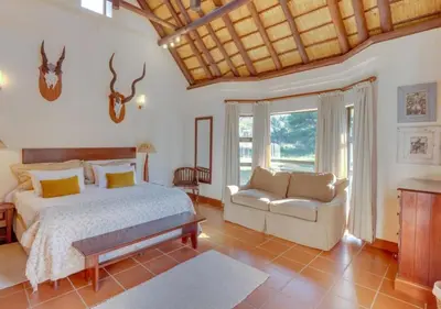 a bedroom with a bed and a couch in a room at Zebula 1 Pela Lodge, 6 bedrooms in Warmbaths