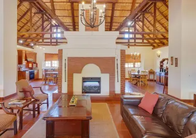 a living room with a couch and a fireplace at Zebula 1 Pela Lodge, 6 bedrooms in Warmbaths