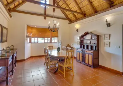 a kitchen and dining room with a table and chairs at Zebula 1 Pela Lodge, 6 bedrooms in Warmbaths