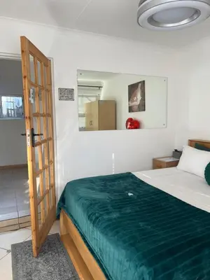 a bedroom with a bed with a green blanket at EasyStay Hideaway in Pretoria