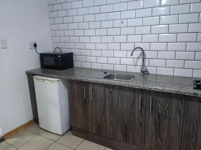 a kitchen with a sink and a microwave on a counter at EasyStay Hideaway in Pretoria