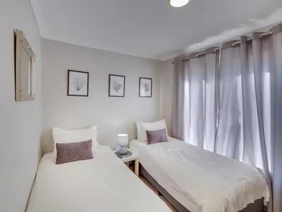 two beds in a room with a window at Zebula 1 Pela Lodge, 2-bedroom cottage in Warmbaths