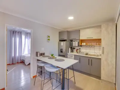a kitchen with a table and chairs in a room at Zebula 1 Pela Lodge, 2-bedroom cottage in Warmbaths
