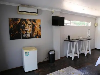a room with a painting of a lion and a table at Malembe Lodge in Midrand