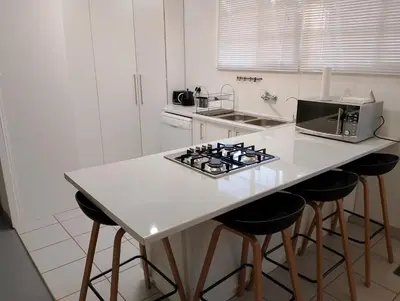 a kitchen with a counter with a stove and stools at TarRoadEnds in Hoedspruit
