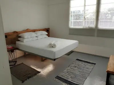 a bedroom with a bed with white sheets and pillows at TarRoadEnds in Hoedspruit