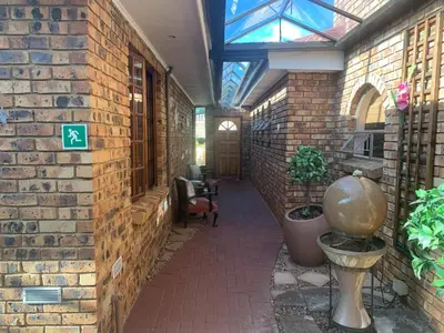 a hallway in a building with a brick wall at Dobbs Lodge in Centurion