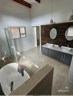 a bathroom with two sinks and a bath tub and a tub at Riverside Self-Catering Accommodation