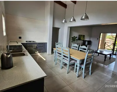 a kitchen and dining room with a table and chairs at Riverside Self-Catering Accommodation