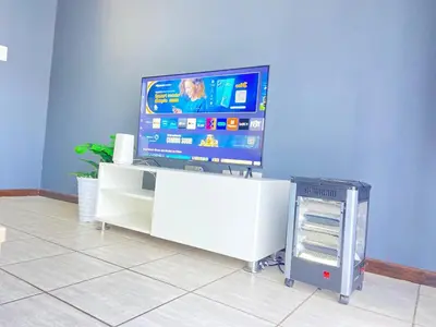 a tv sitting on top of a white entertainment center at A spacious 2bedrooms apartment in the heart of Kempton Park in Kempton Park