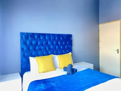 a blue bedroom with a bed with a blue headboard at A spacious 2bedrooms apartment in the heart of Kempton Park in Kempton Park
