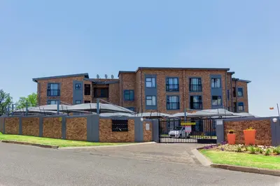 a brick building with umbrellas in front of it at A spacious 2bedrooms apartment in the heart of Kempton Park in Kempton Park