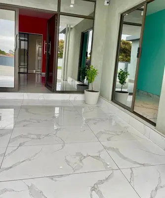 an empty lobby with white marble floors and windows at Lupulo luxury boutique in Thohoyandou