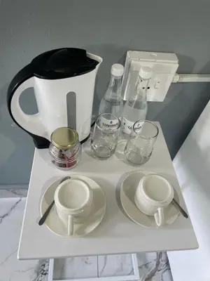 a white shelf with a coffee pot and glasses on it at Lupulo luxury boutique in Thohoyandou