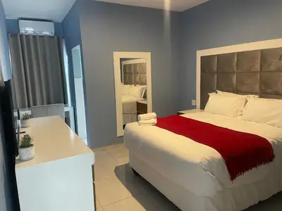 a bedroom with a large bed and a bathroom at Lupulo luxury boutique in Thohoyandou