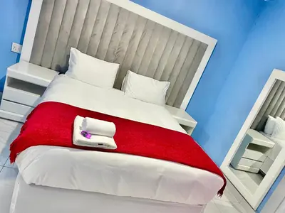 a bedroom with a large bed with a red blanket at Lupulo luxury boutique in Thohoyandou