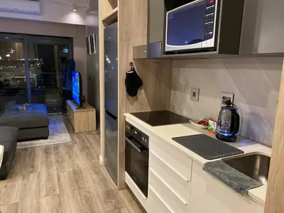 a kitchen with a sink and a microwave at Menlyn Maine Luxury Apartment in Pretoria