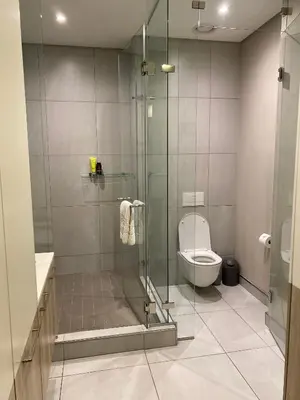 a bathroom with a shower and a toilet at Menlyn Maine Luxury Apartment in Pretoria