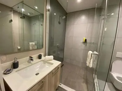 a bathroom with a sink and a shower at Menlyn Maine Luxury Apartment in Pretoria