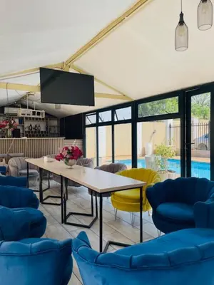 a dining room with a table and chairs and a pool at Henry George Hotel in Pretoria