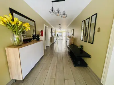 a hallway with a vase of yellow flowers on a counter at Henry George Hotel in Pretoria