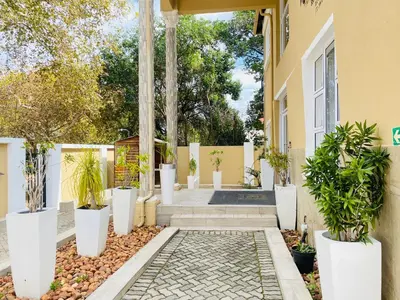 a courtyard with potted plants in front of a house at Henry George Hotel in Pretoria