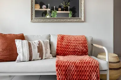 a living room with a couch with pillows and a chair at Chawal Stays Green Valley 1 in Nelspruit