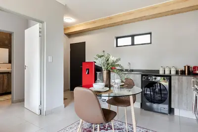 a kitchen with a table and a red refrigerator at Chawal Stays Green Valley 1 in Nelspruit
