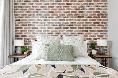 a bedroom with a brick wall and a bed at Chawal Stays Green Valley 1 in Nelspruit