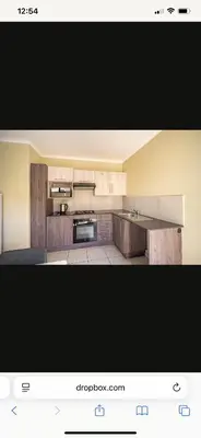 a kitchen with wooden cabinets and a stove top oven at Comfort Zone in Benoni