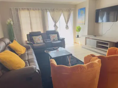 a living room with couches and a couch and a table at Luxury two bedrooms apartment in Witbank overnight accommodation in Witbank