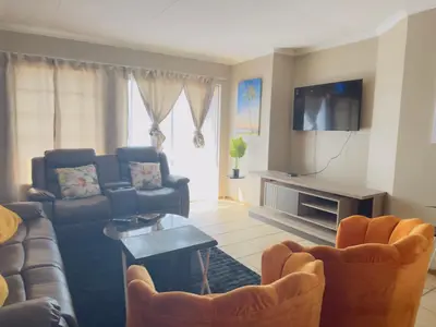 a living room with couches and a flat screen tv at Luxury two bedrooms apartment in Witbank overnight accommodation in Witbank