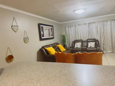 a living room with two chairs and a table at Luxury two bedrooms apartment in Witbank overnight accommodation in Witbank