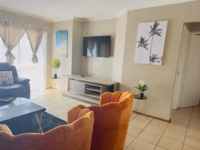 a living room with two chairs and a television at Luxury two bedrooms apartment in Witbank overnight accommodation in Witbank